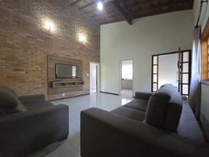 a living room with two couches and a tv at Casa com piscina próxima à natureza in Brotas