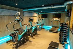 ein Fitnessstudio mit mehreren Cardiogeräten in einem Raum in der Unterkunft Marina Strandbad Chalet Aan het Water mit Zaun Haus Nr 134 in Olburgen