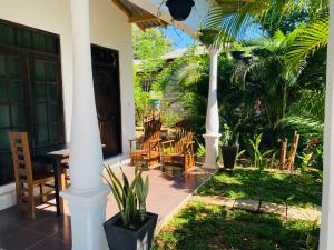 un porche de una casa con sillas y mesa en Fairview Dill homestay, en Sigiriya