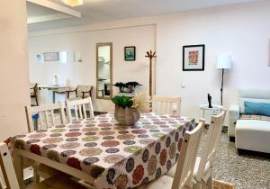 una sala da pranzo con un tavolo con un vaso di fiori sopra di Centrally-Located, Spacious Flat at Historic Centre & short walk to Beach ad Alicante