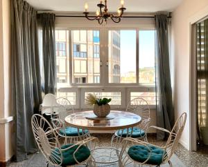 una sala da pranzo con tavolo e sedie e una grande finestra di Centrally-Located, Spacious Flat at Historic Centre & short walk to Beach ad Alicante
