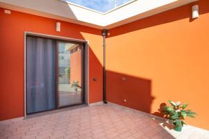 an orange room with a sliding glass door at House 320 in Comiso