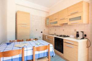 a kitchen with a table with chairs and a stove at House 320 in Comiso