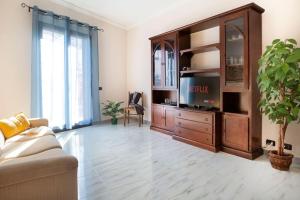 a living room with a large entertainment center with a tv at House 320 in Comiso