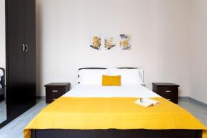a bedroom with a large bed with a yellow blanket at House 320 in Comiso