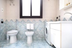 a bathroom with a toilet and a washing machine at House 320 in Comiso +9 photos