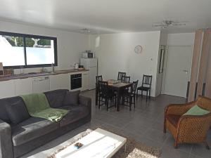 a living room with a couch and a table at Maison de bord de mer - proche plage in La Turballe