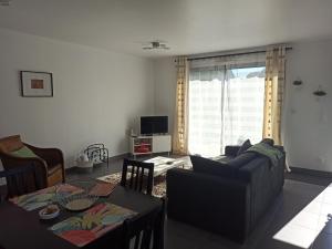a living room with a couch and a table at Maison de bord de mer - proche plage in La Turballe