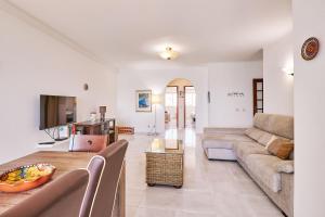 ein Wohnzimmer mit Sofa und Tisch in der Unterkunft Apartment Dean direkt am Meer in Armação de Pêra