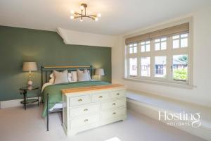 ein Schlafzimmer mit einem Bett mit einer Kommode und einem Fenster in der Unterkunft Dragon Court - 4 Beds with Terrace Garden in Henley on Thames