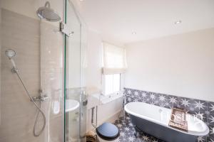 ein Badezimmer mit Badewanne und Glasdusche in der Unterkunft Dragon Court - 4 Beds with Terrace Garden in Henley on Thames + 21 Fotos
