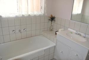 a white bathroom with a tub and a sink at Onocay House in Bright