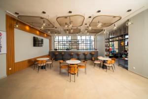a room with tables and chairs and a bar at Avo sports résidence, Dakar-Diamniadio in Dakar