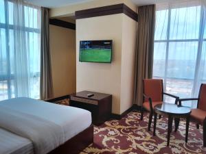 a hotel room with a bed and a tv on the wall at Morena Hotel Morogoro in Morogoro