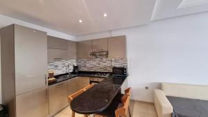 a kitchen with a black counter top in a room at Location saisonniere Appartement Monastir in Sousse