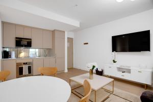 a white living room with a table and a tv at Vonder Miami Beach - Unit 6 in Miami Beach