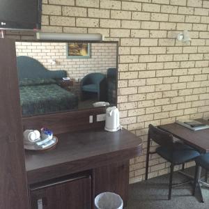 a room with a wooden table and a television at Macquarie Valley Motor Inn in Warren