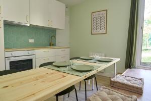 a kitchen with a wooden table with chairs and a dining room at Green Escape - Cozy & Chill in Brunoy