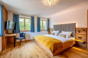 a bedroom with a bed and a desk and a tv at Graf Chiemo Suites - direkt am Chiemsee mit separatem Seezugang in Chieming