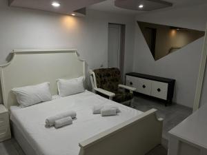 a bedroom with a white bed with towels on it at Kai Hotel Bar in Tbilisi City