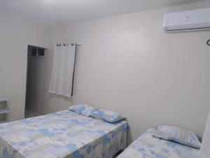a small bedroom with two beds and a heater at Casa flor de Mandacaru in Piranhas