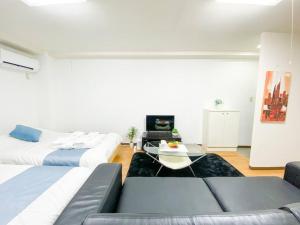 大阪市にある新大阪駅近く A1 Guest House ユニオン新大阪,リーズナブルで長期滞在にも最適のリビングルーム(ベッド2台、コーヒーテーブル付)