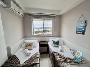zwei Betten in einem kleinen Zimmer mit Fenster in der Unterkunft N6603 VISTA Mar Home Club Beto Carrero in Penha + 70 Fotos