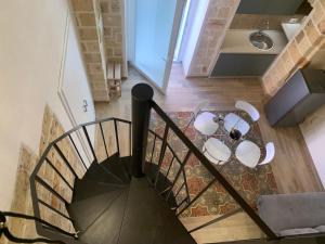 a spiral staircase with a table in a room at Le Dimore del Castello in Nardò