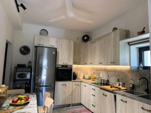 a kitchen with wooden cabinets and a stainless steel refrigerator at South Palms luxury village house in Áno Rodhákinon