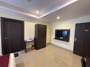 古瓦哈提Hotel Asian Openbill的配有电视、门和电视的房间 更多9张照片