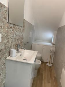 a white bathroom with a toilet and a sink at Le Dimore del Castello in Nardò +37 photos