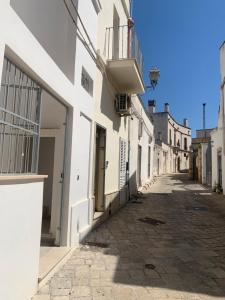 an empty street with white buildings and a balcony at Le Dimore del Castello in Nardò