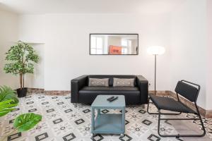 a living room with a black couch and a table at GuestReady - Serene Hideout in Downtown in Porto