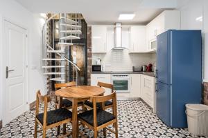 a kitchen with a wooden table and a blue refrigerator at GuestReady - Serene Hideout in Downtown in Porto
