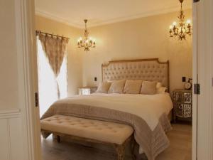 a bedroom with a large bed and a chandelier at Collins Cottage in Bright