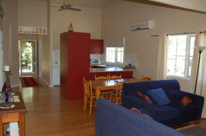 a living room with a blue couch and a table at Corinda Cottage - 4 bedroom pet friendly in Bright