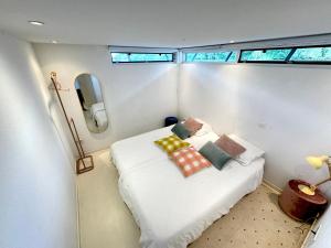 a small room with a bed with pillows on it at Houseboat PURE II in Vreeland