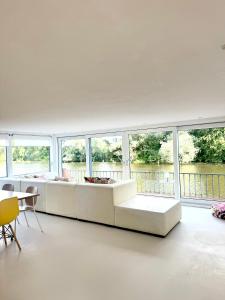 a living room with a white couch and windows at Houseboat PURE II in Vreeland