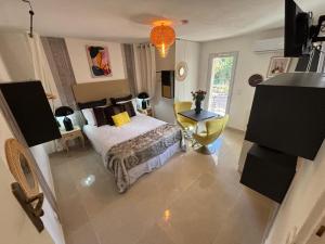 a bedroom with a bed and a yellow chair at Villa Belle Epoque Saint-Raphaël in Saint-Raphaël
