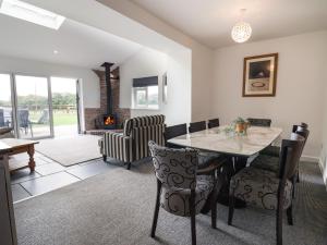 a dining room with a table and chairs and a fireplace at Campion Cottage in Watchet