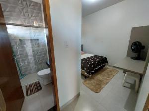 a small bathroom with a bed and a toilet at Suíte Motociclista - Queen's Hotel in Formosa