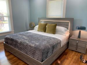 a bedroom with a large bed with yellow pillows at Luxury Designer Villa by the Beach Bright Beautiful Brand New in Galveston