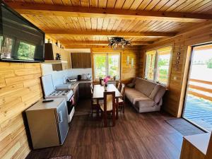 a kitchen and living room of a log cabin at Sowi domek in Płaska