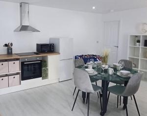 a kitchen and dining room with a table and chairs at Tollymore Lodge in Newcastle
