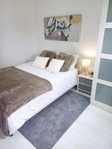 a bedroom with a large white bed with pillows at Tollymore Lodge in Newcastle