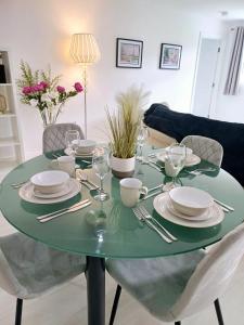 a green table with plates and silverware on it at Tollymore Lodge in Newcastle +17 photos