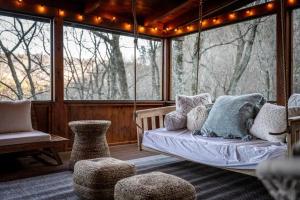 a screened in porch with a bed and a swing at Round Top Way Cabin By Beyond Expectations in Sevierville