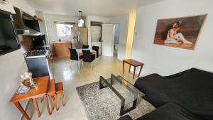 a living room with a couch and a kitchen at Acogedor apartamento en caracas in Caracas