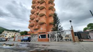 a tall red building with balconies on it at Acogedor apartamento en caracas in Caracas