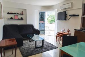 a living room with a black couch and a glass table at Acogedor apartamento en caracas in Caracas